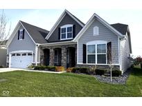 Charming home with stone accents, a well-manicured lawn, and an attached two-car garage at 1295 Clairet Dr, Westfield, IN 46074