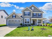 Charming two-story home with a well-manicured lawn and attached two car garage at 12951 Corydon Dr, Fishers, IN 46037