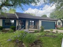 Charming single-story home featuring a well-manicured lawn, flower beds, and attached garage at 1472 Maria Ave, Franklin, IN 46131
