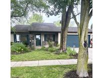 Charming single-story home featuring a well-maintained lawn, mature trees, and a blue two-car garage at 1472 Maria Ave, Franklin, IN 46131