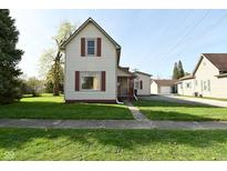 Charming two-story home with a well-maintained lawn and a detached garage; inviting curb appeal at 1615 N E St, Elwood, IN 46036