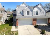 Charming home with an attached two car garage, gray siding, brick accents, and well-maintained landscaping at 1884 Misty Lake Dr, Indianapolis, IN 46260