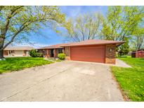 Charming single-story home with a brick facade, a spacious driveway, and a two-car garage at 1908 Roundhill Dr, Anderson, IN 46013