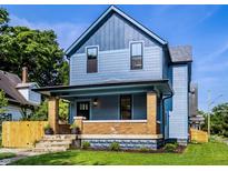 Charming two-story home featuring a covered front porch with brick supports and a well-maintained lawn at 3868 N Park Ave, Indianapolis, IN 46205