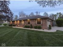 Charming single-story brick home with manicured lawn and landscape lighting for beautiful curb appeal at 4037 Hazy Ln, Greenwood, IN 46142