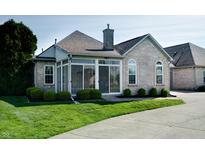 Beautiful sunroom featuring sliding windows, brick chimney, and a landscaped yard at 5839 Quail Run Dr, Indianapolis, IN 46237