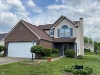 Charming two-story home with brick and vinyl siding, a well-manicured lawn, and a two car garage at 621 Jack Pine Ct, Indianapolis, IN 46224