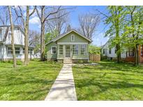 Charming green home with a bright sunroom and a well-maintained lawn at 6307 Broadway St, Indianapolis, IN 46220