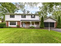 Charming two-story home featuring a brick and white facade, inviting porch, and well-maintained front lawn at 7140 Avalon Trail Dr, Indianapolis, IN 46250
