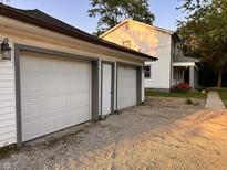 An exterior shot of the garage including a gravel driveway at a charming two-story home at 728 W 300 N, Anderson, IN 46011