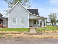 Charming light blue single-story home with a covered porch and well-maintained yard at 917 S Grant St, Muncie, IN 47302