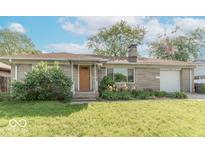 Charming single-story home with stone exterior and a well-maintained front yard and landscaping at 1021 N Bolton Ave, Indianapolis, IN 46219