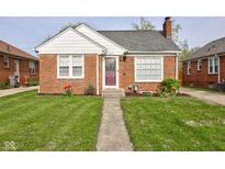 Charming brick home featuring a well-manicured lawn, classic architecture, and inviting front entrance at 1209 N Downey Ave, Indianapolis, IN 46219