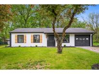 Charming single-story home with a well-maintained lawn and stylish black and white exterior at 1295 Rolling Ridge Dr, Noblesville, IN 46060