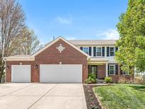 Charming two-story brick home featuring a three-car garage and well-maintained landscaping, perfect for Gathering living at 3582 Fieldhurst Ln, Plainfield, IN 46168