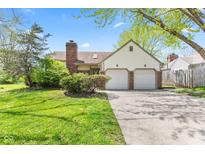 Charming home with a two-car garage and well-maintained front yard and brick chimney at 4322 Matrea More Ct, Indianapolis, IN 46254
