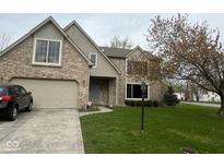 Charming brick home featuring a two-car garage, well-manicured lawn, and mature trees at 5640 Dapple Ct, Indianapolis, IN 46228