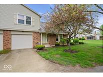 Charming two-story home with a well-maintained lawn, mature flowering tree, and attached garage at 7424 Prairie Lake Dr, Indianapolis, IN 46256