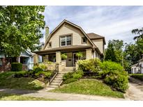 Charming two-story home with a landscaped front yard, brick accents, and a welcoming front porch at 1044 E Garfield Dr, Indianapolis, IN 46203