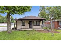 Charming single-story home featuring a cozy front porch and mature trees in a serene neighborhood at 1953 N Alton Ave, Indianapolis, IN 46222