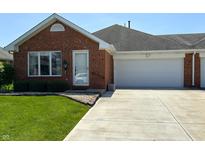 Charming brick home featuring an attached two-car garage and well-maintained front lawn at 379 Vinewood N Dr, Brownsburg, IN 46112