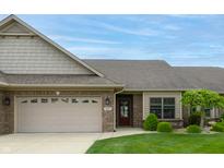 Charming brick home featuring a manicured lawn, attached two car garage, and covered entry way at 4061 Melbourne Dr, Columbus, IN 47203