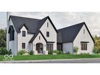 Charming white brick home with a dark roof and black trim, complemented by lush green landscaping at 5488 Stonewood Ct, Bargersville, IN 46106