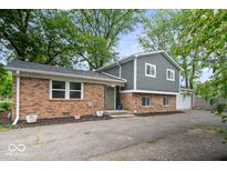 Charming exterior view of a two-story home featuring a brick facade, gray siding, and a well-manicured front yard at 5719 Laurel Hall Dr, Indianapolis, IN 46226
