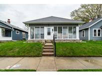 Charming single-story home featuring a glass-enclosed front porch and well-maintained lawn at 71 S 9Th Ave, Beech Grove, IN 46107