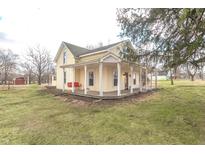 Charming two-story home featuring a welcoming front porch with a porch swing and spacious front yard at 7561 N Hall School Rd, Monrovia, IN 46157