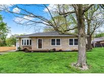 Charming stone home featuring a well-maintained lawn and mature shade trees at 840 N Indiana St, Mooresville, IN 46158