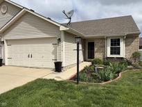 Charming home with a well-maintained lawn, complemented by a two-car garage and beautifully landscaped flowerbeds at 1316 Long Shore Dr, Indianapolis, IN 46217