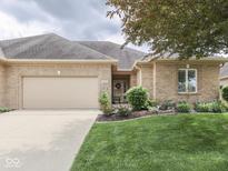 Charming brick home featuring an attached garage, manicured lawn, and lovely landscaping at 1395 Heron Ridge Blvd, Greenwood, IN 46143