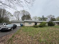 Single-story home featuring an attached garage and mature landscaping at 1532 Greer Dell Rd, Indianapolis, IN 46260