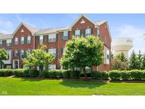 Charming brick townhouse featuring a well-manicured lawn and tasteful green shutters at 3546 Golden Gate N Dr, Carmel, IN 46074