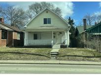 Welcoming home featuring a classic front porch with white columns and railings, complemented by a neat lawn and a clear sky at 537 N Rural St, Indianapolis, IN 46201