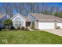 Charming home featuring an attached garage, well-maintained lawn, and lush landscaping at 5982 Blue Heron Way, Plainfield, IN 46168
