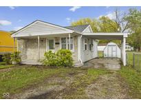 Charming home with stone accents, a convenient carport, and a well-maintained yard at 729 S Holmes Ave, Indianapolis, IN 46221