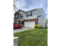 Two-story home with a brick and vinyl exterior, attached two-car garage, and a well-maintained lawn at 10190 Holly Berry Cir, Fishers, IN 46038