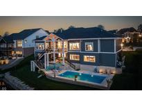 Stunning backyard view with a pristine pool, manicured lawn, and outdoor seating areas, perfect for relaxing and entertaining at 10590 Geist View Dr, Fishers, IN 46055
