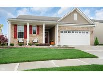 Charming single-Gathering home boasts a manicured lawn, brick facade, and inviting front porch at 16201 Haywood St, Fishers, IN 46037