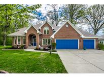 Charming brick home boasts a manicured lawn, blue garage doors and complementary blue front door at 225 Yorkshire E Blvd, Indianapolis, IN 46229