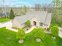 Stunning home featuring manicured lawn, brick facade, complemented by verdant greenery, mature trees, and a charming walkway at 2733 Foxborough Dr, Greenwood, IN 46143