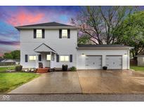 Charming two-story home featuring a two-car garage, a manicured lawn, and a cozy front porch at 301 S B St, Thorntown, IN 46071