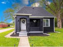 Charming black exterior with lush lawn, flower basket, and a welcoming white door at 3132 Indianapolis Ave, Indianapolis, IN 46208