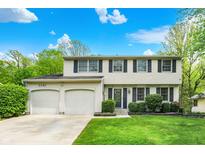 Charming two-story home features a well-manicured lawn and an attached two-car garage at 5341 Armstrong Dr, Indianapolis, IN 46237