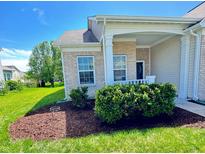 Charming brick home featuring a cozy front porch and well-maintained landscaping, complete with mulch and shrubbery at 5839 W Commonview Dr, McCordsville, IN 46055
