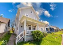Charming two-story home with a covered front porch, well-manicured lawn, and inviting curb appeal at 623 Arbor Ave, Indianapolis, IN 46221