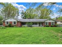 Charming one-story brick home with large front yard and mature trees creating a welcoming curb appeal at 7804 Wawasee Dr, Indianapolis, IN 46250