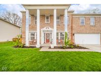 Inviting brick home with white columns, benches on the front porch, and a well-manicured lawn at 10090 Eagle Eye Way, Indianapolis, IN 46234